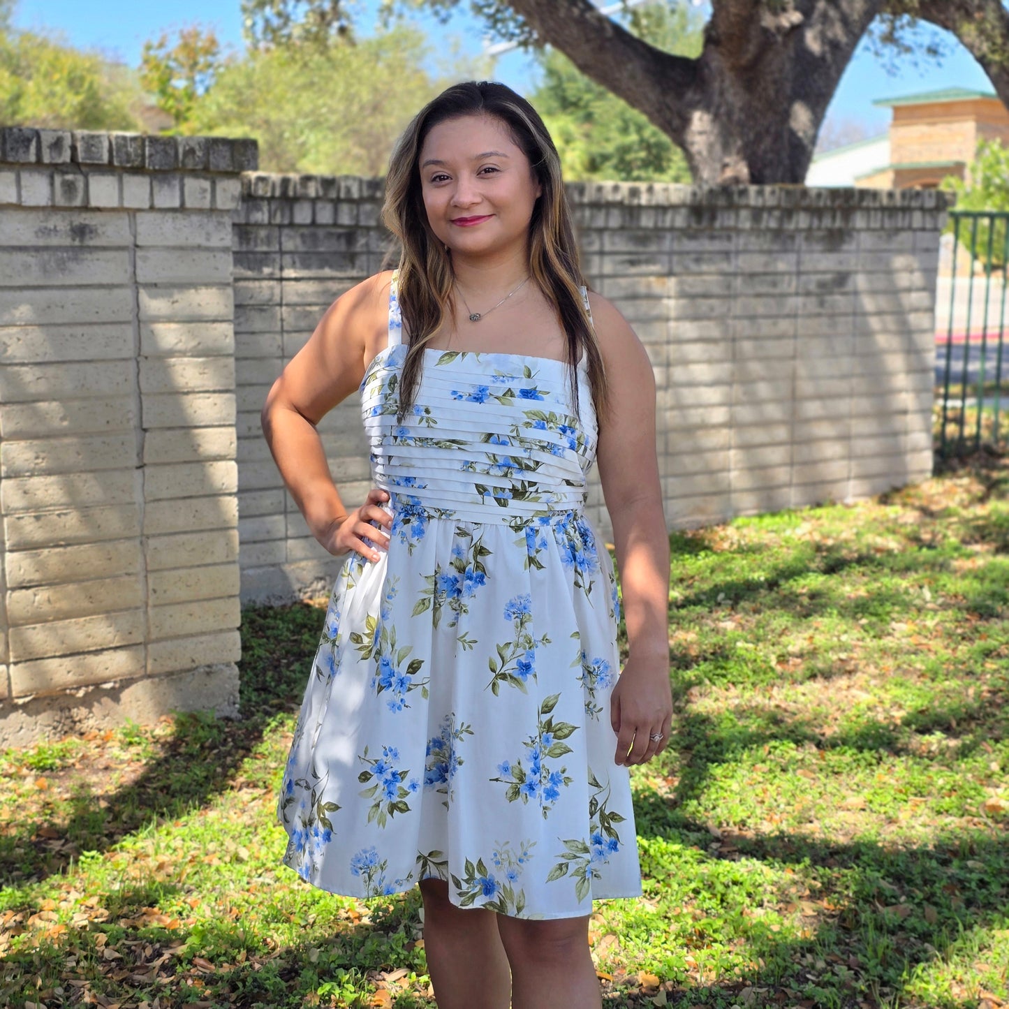 White and blue floral dress with square neckline, pleated bodice, and flowy skirt. Perfect for spring, brunch, showers, and special occasions.
