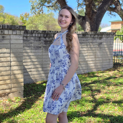 Blue floral mini dress with halter or crisscross neckline. Flowy, feminine, and perfect for spring events, brunch, and everyday style.