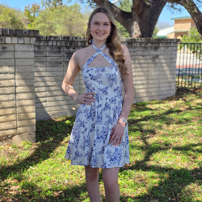 Blue floral mini dress with halter or crisscross neckline. Flowy, feminine, and perfect for spring events, brunch, and everyday style.