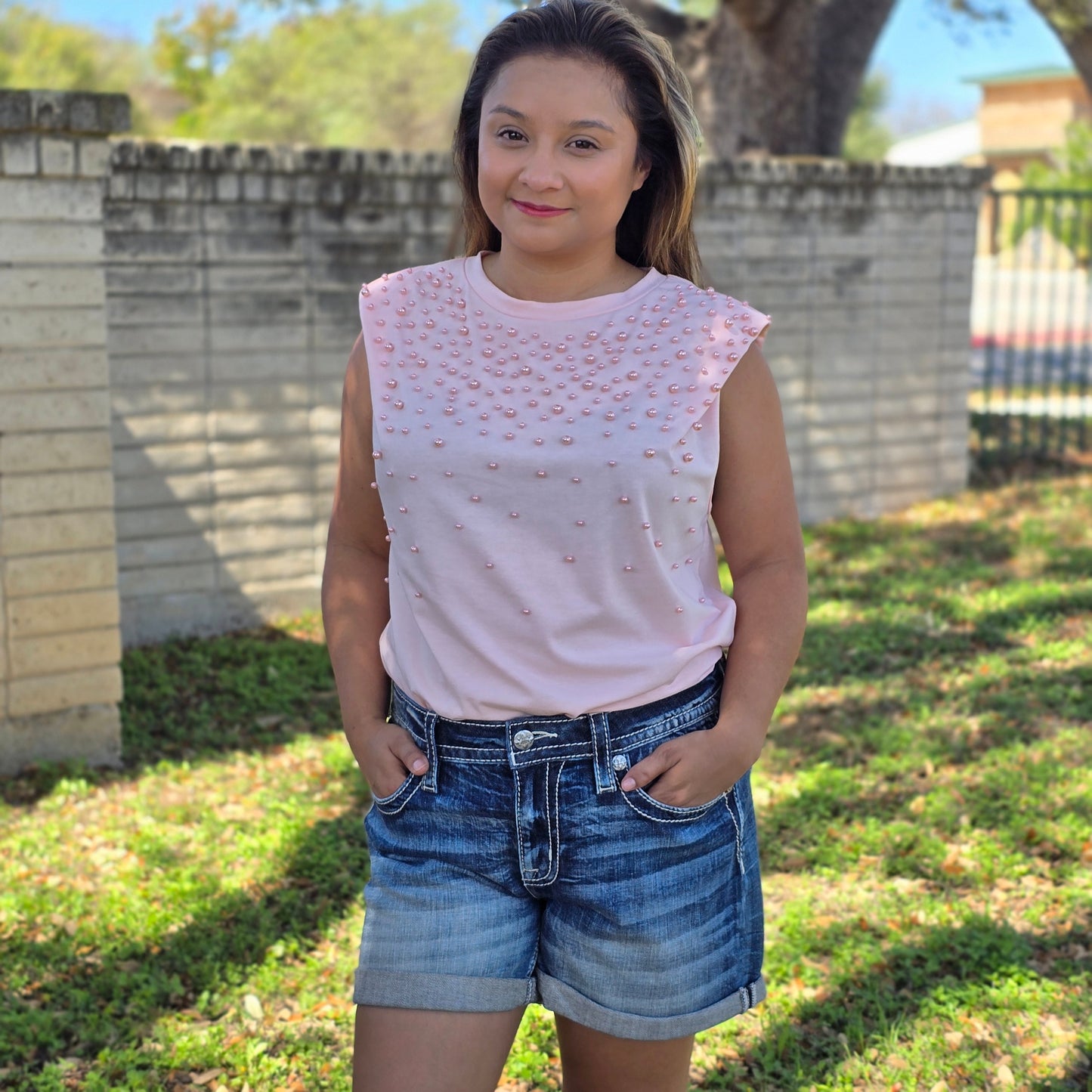 Blush pink sleeveless top with pearl embellishments and relaxed fit. Chic, feminine, and perfect for casual wear, work, or dressing up denim.