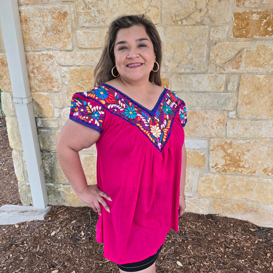 Pink dress with colorful embroidery.